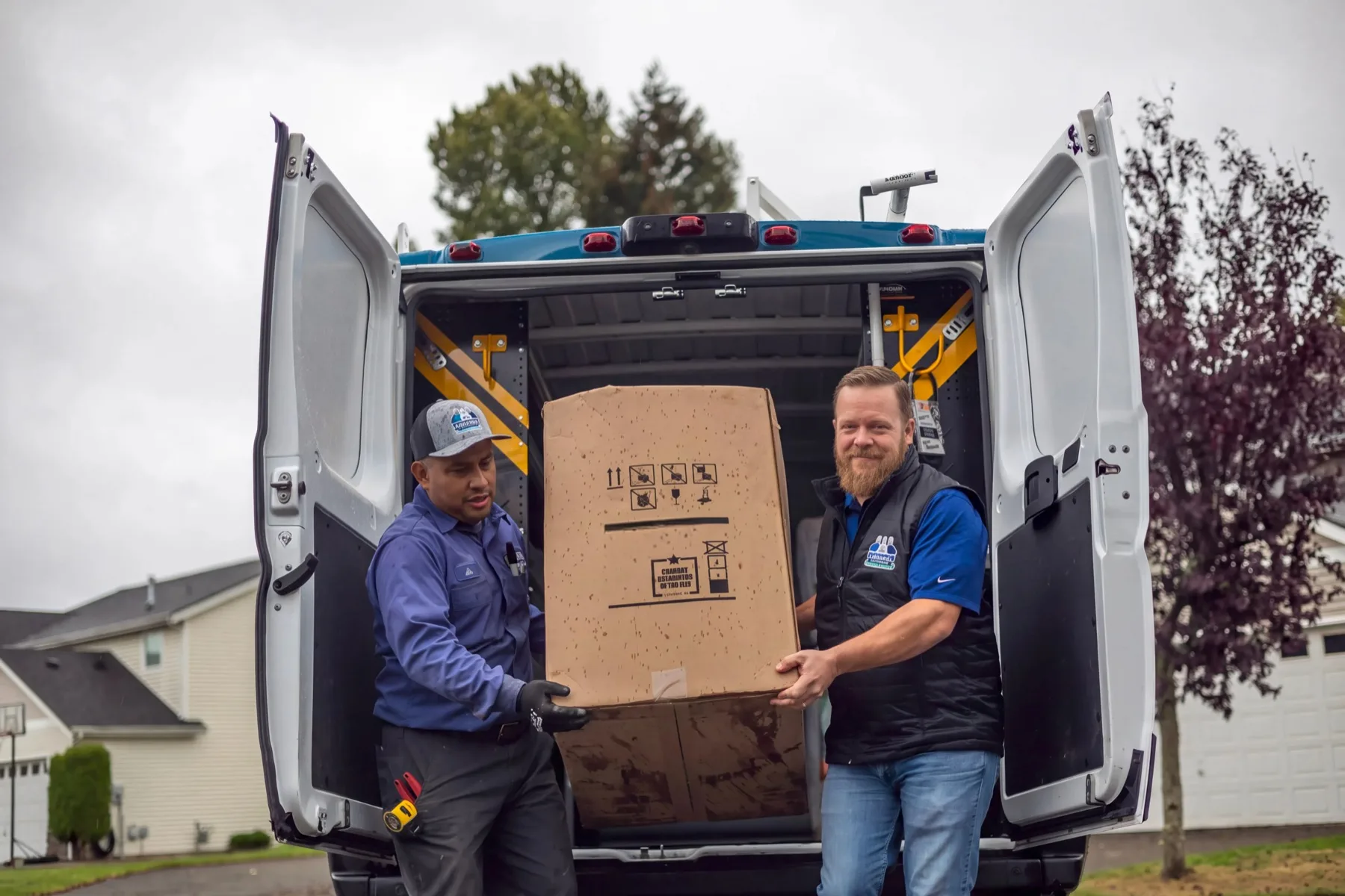 Two Kliemann Brothers technicians unloading new equipment from a company van