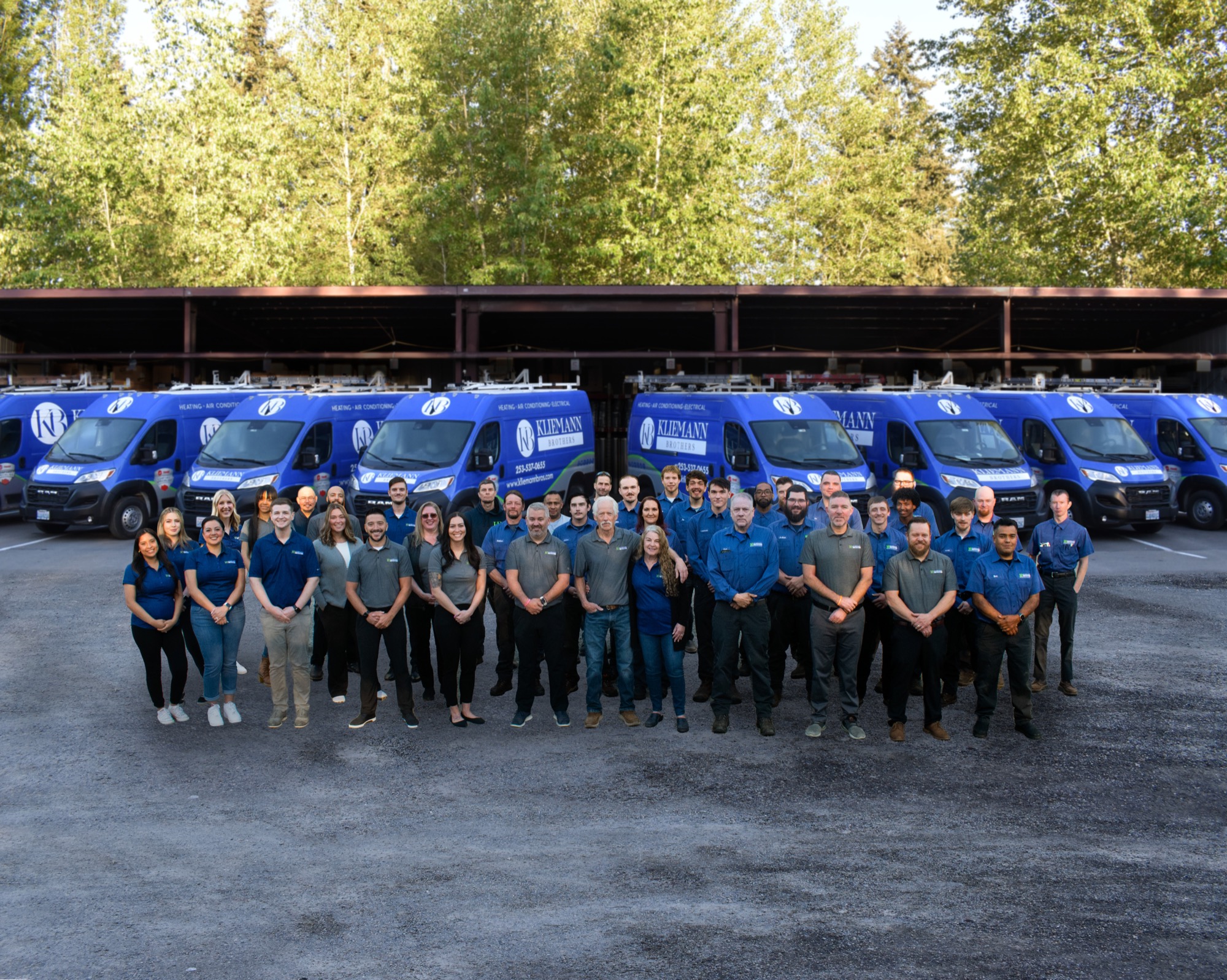 The Kliemann Brothers team of technicians standing together in front of company vans