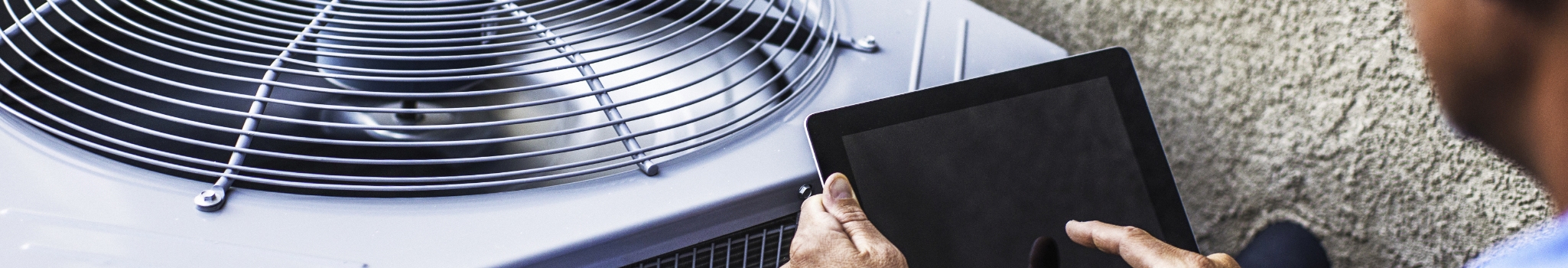 Maintenance engineer using digital tablet to inspect air conditioning unit